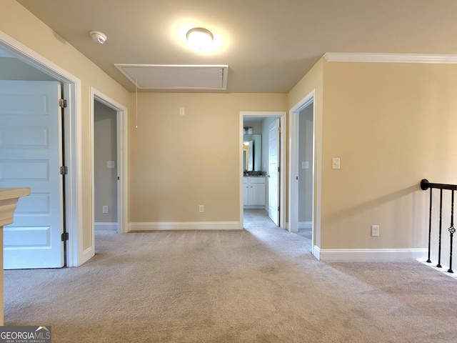spare room featuring attic access, baseboards, and carpet flooring
