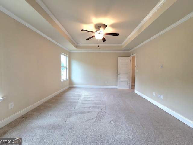 unfurnished room featuring a ceiling fan, crown molding, carpet, baseboards, and a raised ceiling