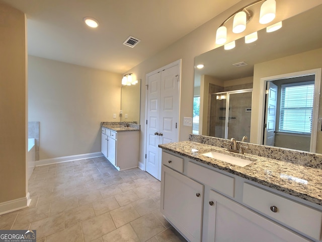 full bathroom with visible vents, a sink, baseboards, two vanities, and a stall shower