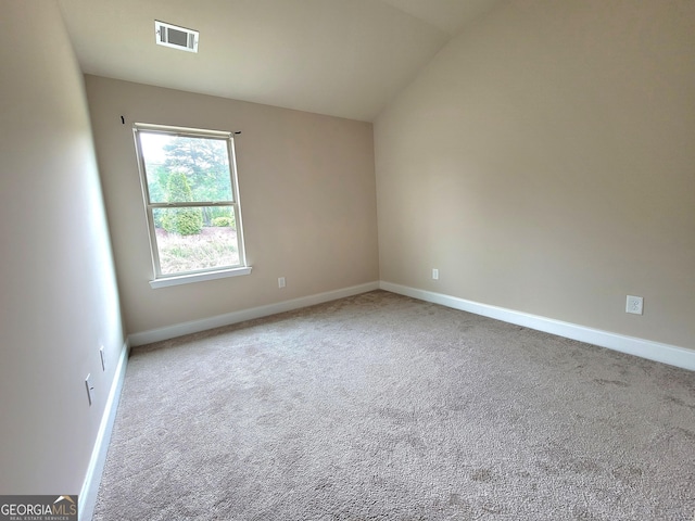 carpeted empty room featuring baseboards, vaulted ceiling, and visible vents