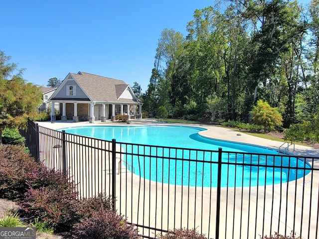 community pool with a patio and fence