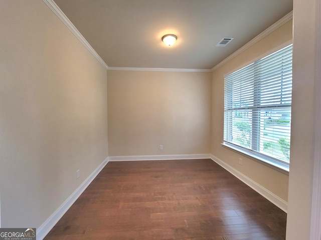 unfurnished room featuring dark wood-style floors, baseboards, ornamental molding, and visible vents