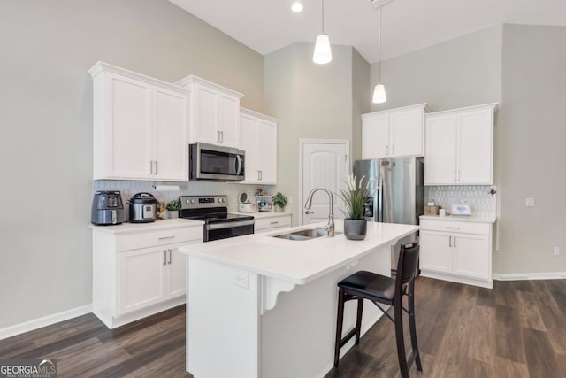 128 Clearwater Dr, Brunswick, GA 31523 - kitchen featuring white cabinets, stainless steel appliances, a sink, decorative backsplash, and a kitchen island with sink