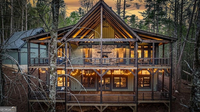 back of property at dusk with board and batten siding and a wooden deck