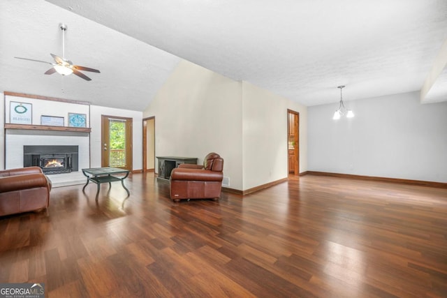 living area with baseboards, wood finished floors, and a lit fireplace