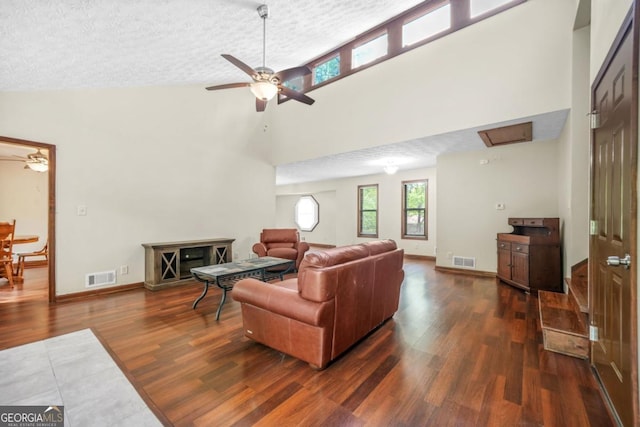 living area featuring wood finished floors, visible vents, a textured ceiling, high vaulted ceiling, and ceiling fan