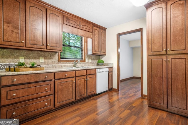 kitchen with white dishwasher, a sink, decorative backsplash, light countertops, and dark wood-style floors