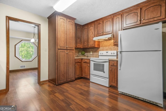 kitchen featuring dark wood finished floors, visible vents, decorative backsplash, white appliances, and under cabinet range hood