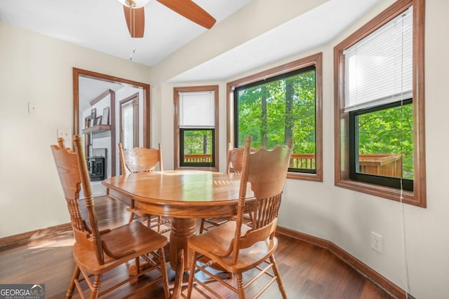 dining room featuring wood finished floors, a wealth of natural light, baseboards, and ceiling fan