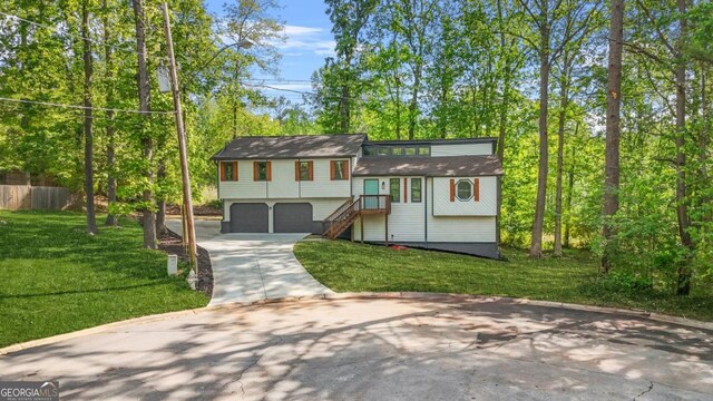 view of front of home with a garage, driveway, a front lawn, and stairs