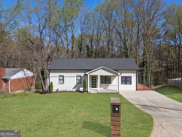 ranch-style home featuring board and batten siding, a front lawn, driveway, and covered porch