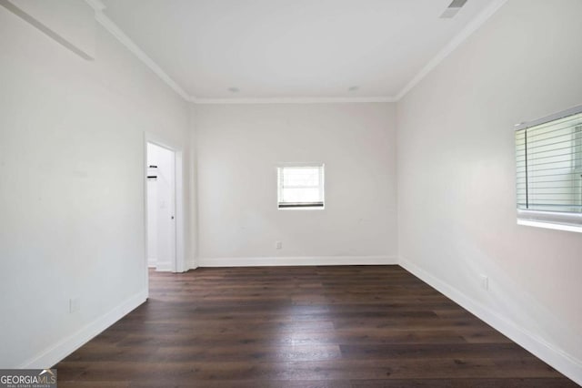 spare room with wood finished floors, crown molding, and baseboards