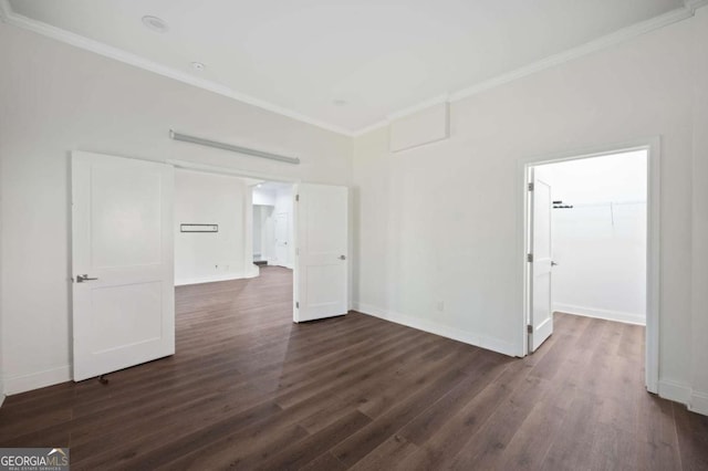 spare room with dark wood-style flooring, baseboards, and ornamental molding
