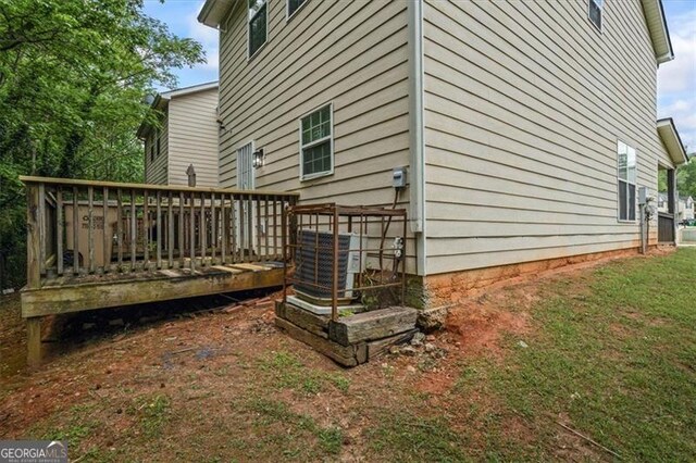 view of side of home with central AC and a deck
