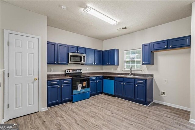 kitchen with dark countertops, a sink, range with electric stovetop, dishwasher, and stainless steel microwave