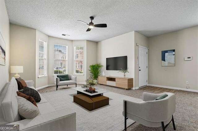 living area with carpet floors, baseboards, and ceiling fan