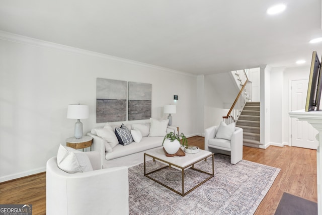 living area with baseboards, recessed lighting, wood finished floors, stairs, and ornamental molding