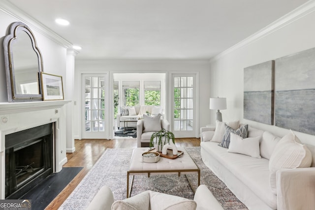 living room with a fireplace with flush hearth, wood finished floors, crown molding, and recessed lighting