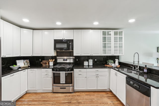 kitchen with white cabinets, ornamental molding, a sink, tasteful backsplash, and appliances with stainless steel finishes
