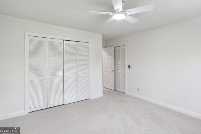 unfurnished bedroom with light colored carpet, baseboards, a ceiling fan, and a closet