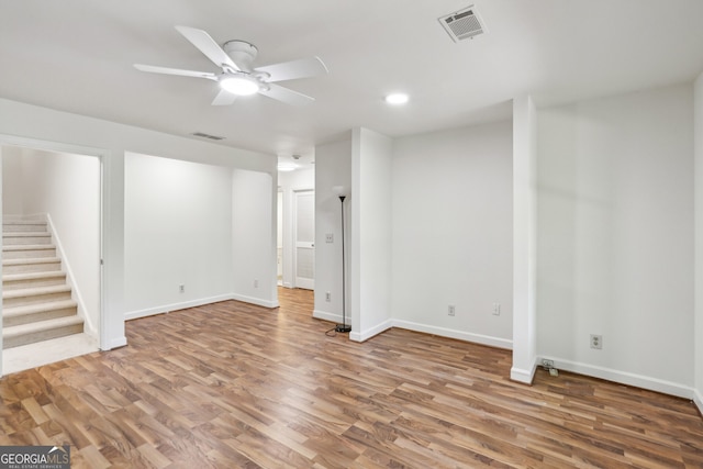 basement featuring wood finished floors, visible vents, stairs, and ceiling fan