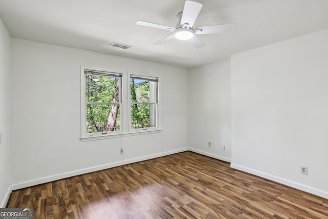 empty room featuring baseboards, a ceiling fan, wood finished floors, and visible vents