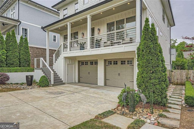 1059 Antioch Dr, Brookhaven, GA 30319 - coastal home with a garage, fence, board and batten siding, concrete driveway, and stairway