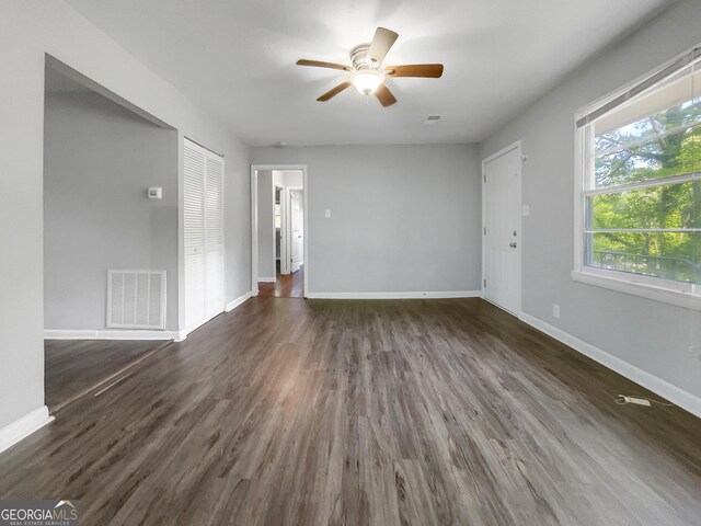 233 Banberry Dr SE, Atlanta, GA 30315 - unfurnished living room featuring dark wood-style flooring, a ceiling fan, visible vents, and baseboards