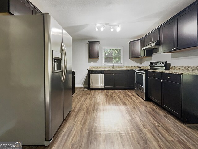 233 Banberry Dr SE, Atlanta, GA 30315 - kitchen with a sink, wood finished floors, light stone counters, under cabinet range hood, and appliances with stainless steel finishes
