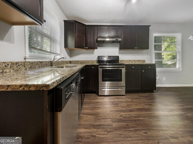 233 Banberry Dr SE, Atlanta, GA 30315 - kitchen with under cabinet range hood, a sink, dark wood-type flooring, and appliances with stainless steel finishes