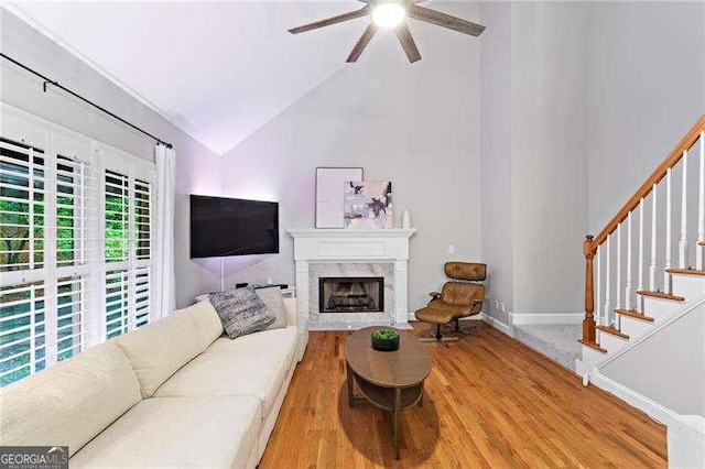 5729 Brookstone Walk NW, Acworth, GA 30101 - living room with wood finished floors, a ceiling fan, a premium fireplace, stairs, and high vaulted ceiling