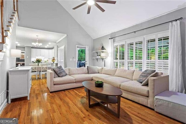 5729 Brookstone Walk NW, Acworth, GA 30101 - living room with ceiling fan, high vaulted ceiling, light wood-style floors, and a chandelier