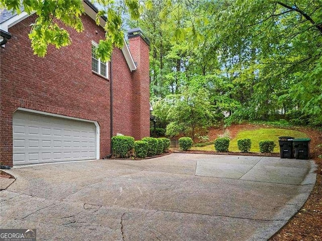 5729 Brookstone Walk NW, Acworth, GA 30101 - view of property exterior with concrete driveway, a garage, a chimney, and brick siding