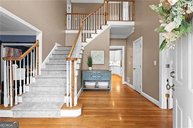 5729 Brookstone Walk NW, Acworth, GA 30101 - foyer featuring wood finished floors, stairway, crown molding, baseboards, and a towering ceiling