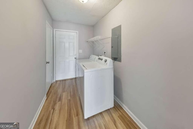 laundry area with washer and dryer, light wood finished floors, electric panel, and laundry area