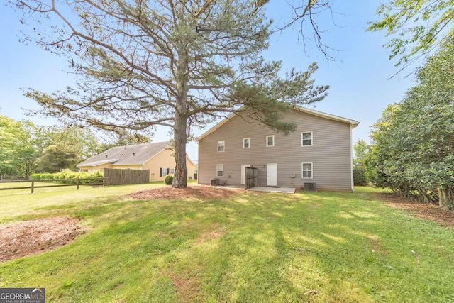 view of side of home with a yard, central AC, a patio, and fence