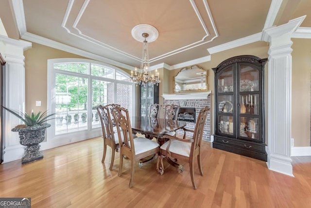 988 Hunters Rdg, Jasper, GA 30143 - dining area with ornate columns, a tray ceiling, light wood-style flooring, and a fireplace