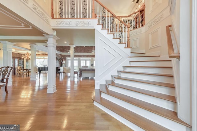988 Hunters Rdg, Jasper, GA 30143 - staircase featuring a high ceiling, decorative columns, and wood finished floors