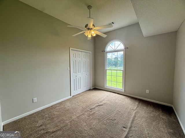 1087 Forsyth Landing Dr, Forsyth, GA 31029 - unfurnished bedroom featuring carpet, a textured ceiling, a closet, a ceiling fan, and lofted ceiling