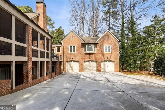 4835 Merlendale Ct, Atlanta, GA 30327 - exterior space with driveway, a chimney, brick siding, and a garage