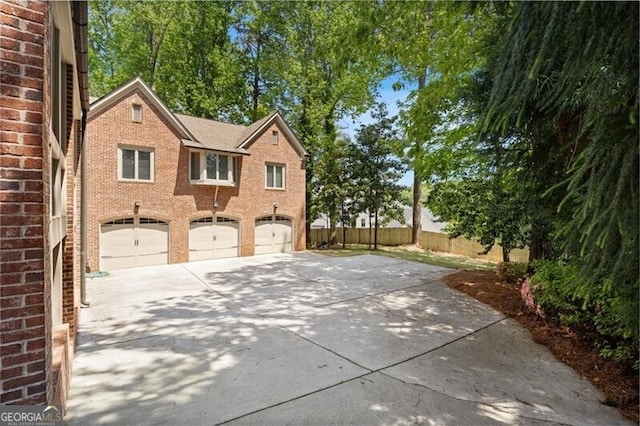 4835 Merlendale Ct, Atlanta, GA 30327 - view of side of property with a garage, brick siding, concrete driveway, and fence