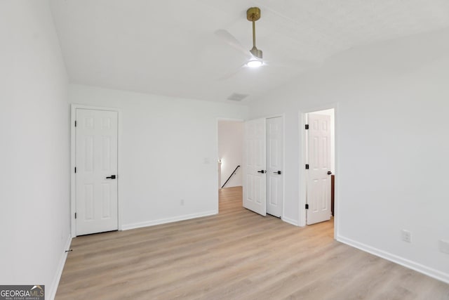 bedroom with baseboards, a ceiling fan, wood finished floors, and visible vents