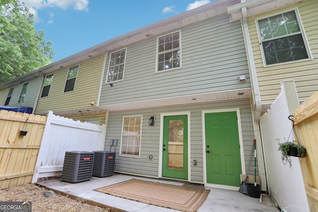 rear view of property with a patio, central AC unit, and fence