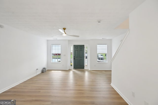 living area with baseboards, a tiled fireplace, wood finished floors, and ceiling fan
