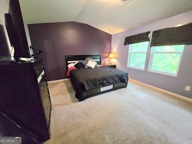 carpeted bedroom with vaulted ceiling and baseboards