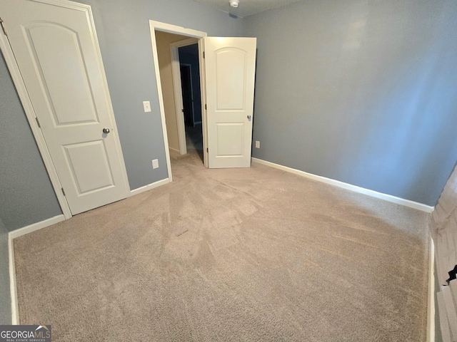 unfurnished bedroom featuring carpet flooring and baseboards