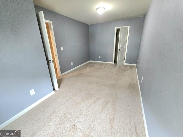 spare room featuring carpet floors and baseboards