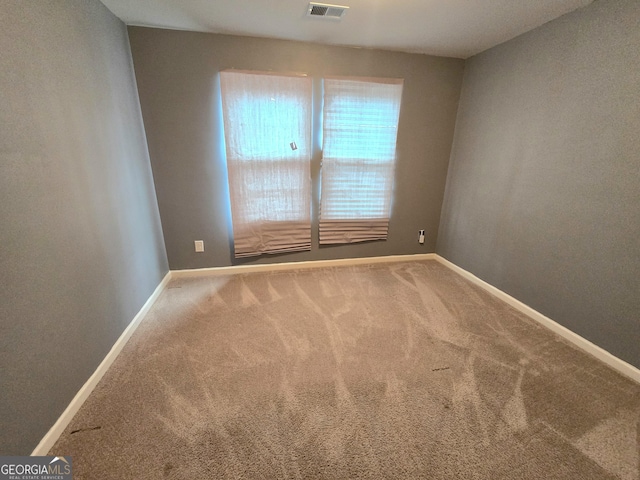 carpeted spare room featuring baseboards