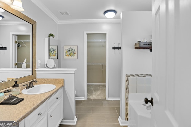full bath with crown molding, a walk in closet, vanity, a tub to relax in, and visible vents