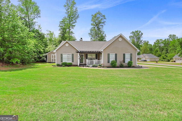 ranch-style house with a shingled roof, a chimney, a porch, and a front yard